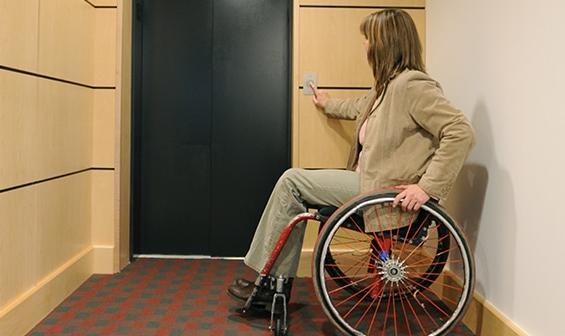 Handicapped woman using a Limited Use Limited Application Elevator