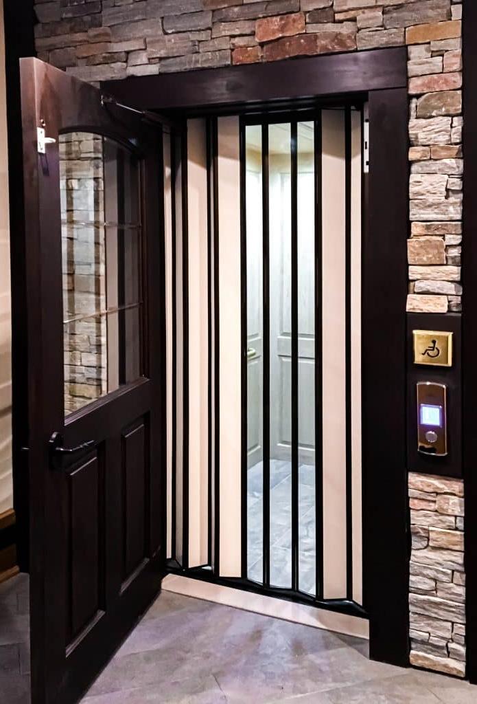 bifold glass elevator with stone surround